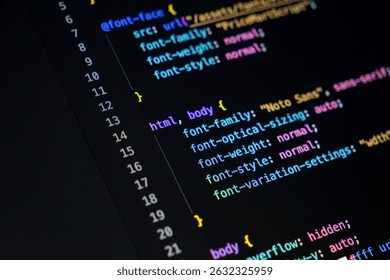Close-up of a monitor with a dark background featuring colorful code snippets, indicative of an active programming session or a general coding interface