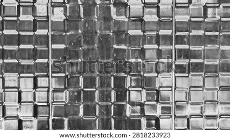 Close-up monochrome patterned glass texture background. Vintage frosted glass with square geometric grid design