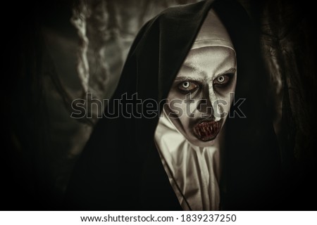 Close-up monochrome portrait of a devilish scary nun with terrible teeth. Halloween and Horrors.