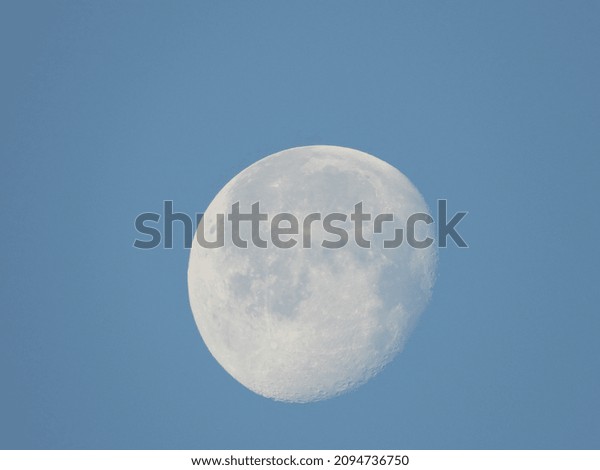 closeup of the moon\
with blue sky\
background
