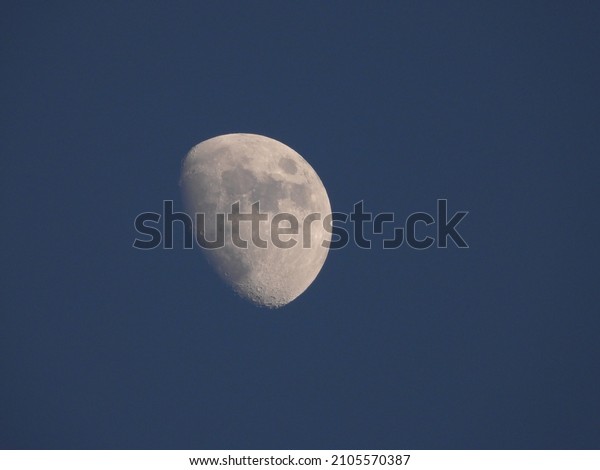 closeup of the moon\
with blue sky\
background