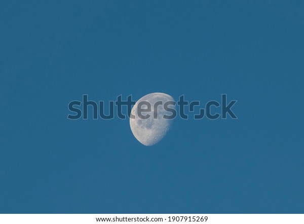 Close-up moon\
in the blue sky.  Nature\
background.