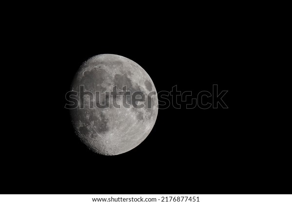 Close-up moon in waxing gibbous phase, moon
surface, craters and the night sky isolated on a black background
and copy space
