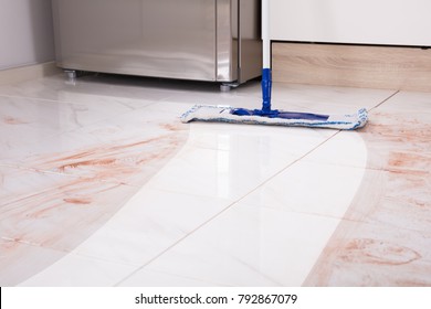 Close-up Of Mop In Kitchen Cleaning Dirty Floor At Home