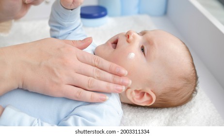 Closeup Of Mother Applying Moisturizing Baby Creme To Prevent Dry Skin. Concept Of Hygiene, Baby Care And Healthcare.