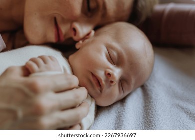 Close-up of mother cuddling with her newborn baby in their bad. - Shutterstock ID 2267936697