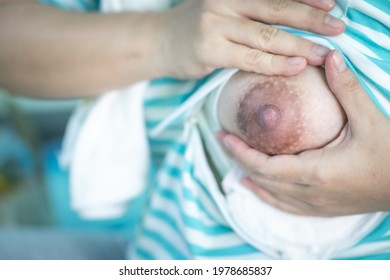 Close-up of a mother squeezing milk out of her breast by hand. Hand expression or manual expression