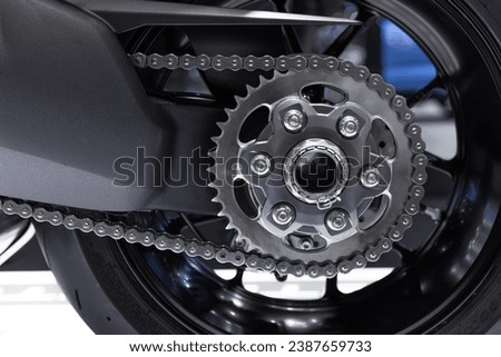 closeup motorcycle chain gear rear wheel for big bike high speed performance clean new.