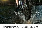 Close-up of mountain rider splashing water in river. Freeze motion of active lifestyle.