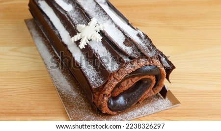 Closeup of Mouthwatering Chocolate Yule Log Christmas Cake or Buche de Noel on Wooden Table