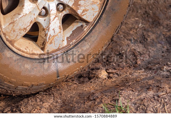 Close-up of muddy car\
wheels. Space for text