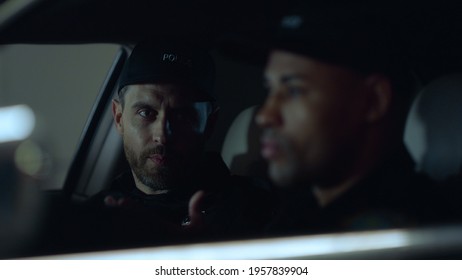 Closeup Multi Ethnic Policemen Sitting In Patrol Car At Operation. Portrait Of Male Cops Talking In Police Vehicle. Police Officers Watching Criminal From Suv During Special Operation