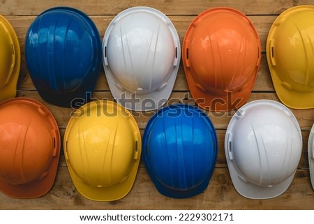 Close-up, multi-colored construction helmets for engineering and worker construction site hanging on an old wooden wall