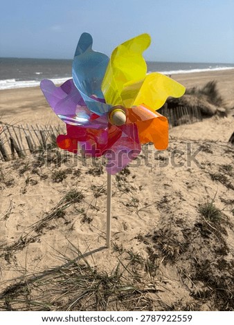 Closeup Of A Multicoloured  Windmill On Sandy Beach Dunes