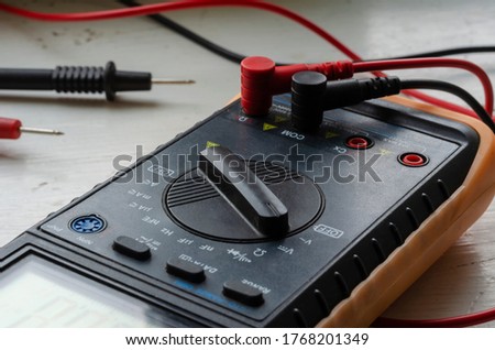 Close-up of a multimeter on a light background. Detailed shot of a measuring device. Qualified electrician services. Selective focus.