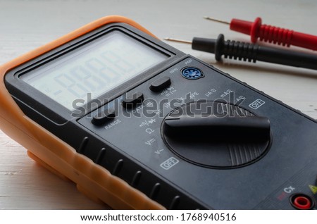 Close-up of a multimeter on a light background. Detailed shot of a measuring device. Qualified electrician services. Selective focus.