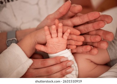 Close-up of multiple hands from different generations, symbolizing family unity and love. Adult and baby hands create a touching scene of connection and support