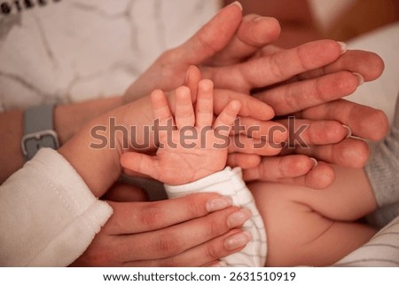 Close-up of multiple hands from different generations, symbolizing family unity and love. Adult and baby hands create a touching scene of connection and support