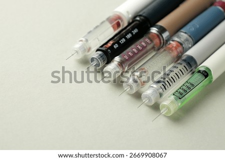 Close-up of multiple injection pens with needles. Concept of semaglutide, GLP-1 drugs, insulin therapy, obesity treatment, diabetes care, pharmaceutical market and weight loss medication