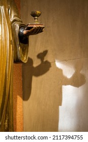 A closeup of multiple shadows of a statue hand holding a cup - Shutterstock ID 2117394755