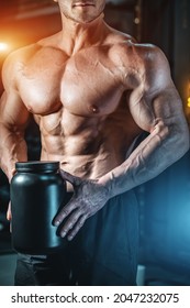 Closeup Of Muscular Athlete Holding Black Container With Protein Whey Supplement