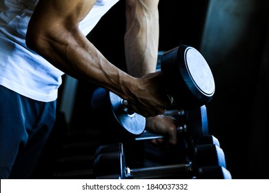 Closeup of muscular young man lifting weights. handsome weightlifter athletic man workout with dumbbell power exercise in gym.Fitness man with dumbbell in sport club. Sport, exercise, fitness concept.