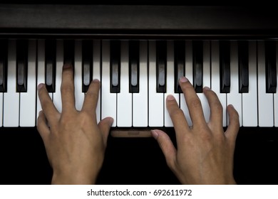 closeup musician hands playing piano on piano keyboard.low key tone image.concept for live music festival.Instrument on stage,classical music.abstract musical background.