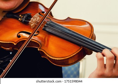 Close-up of a musician performing a musical composition using a violin and a bow. Violin musical instrument violinist hands.