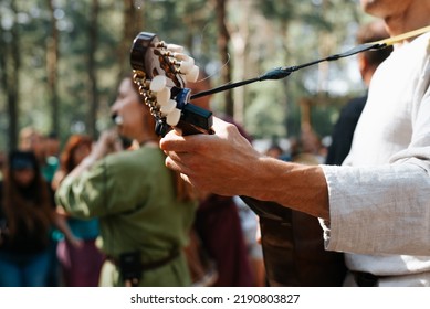 Close-up of a musician playing the guitar outdoors. Musical folk group at a street festival. Selective focus on guitarist's hand. - Shutterstock ID 2190803827