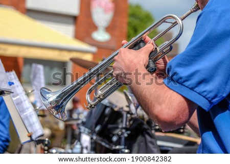Close-up of a musician plays the trumpet in a big band at a public concert outdoors- selective focus