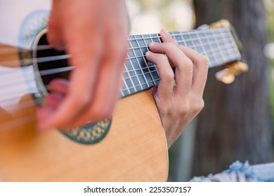 Close-up of the musician's playing hands. The guitarist plays the guitar. Professional guitarist plays guitar outdoors. Musician plays a classical guitar in the park. - Powered by Shutterstock