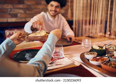 Close-up Of Muslim Couple Eating Traditional Lafah Bread During Dinner At Dining Table On Ramadan At Home.