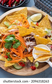 Close-up Of Nachos Chips With Shredded Barbecue Chicken, Vegetables And Dipping Sauce On A Wooden Serving Tray