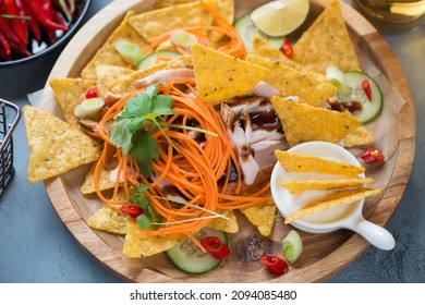 Closeup Of Nachos Chips With Shredded Chicken Meat, Vegetables, Greens And Dip Sauce, Horizontal Shot