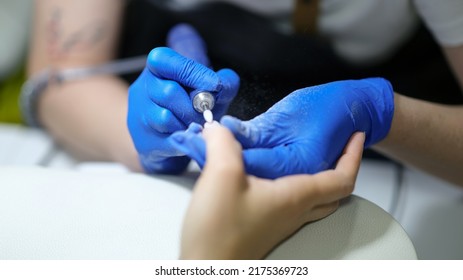 Close-up of nail specialist doing manicure to client using special apparatus, hardware manicure. Beauty day and manicurist concept Foto Stock