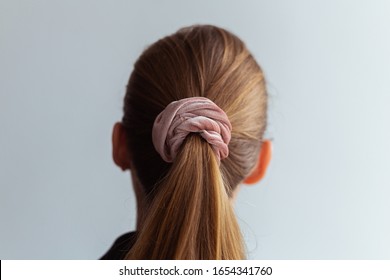 Close-up Of A Natural Blonde Hair, Tied Up In A Ponytail By Pink Velvet Scrunchie, Back View 