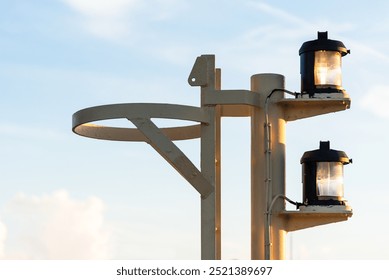 Close-up of navigation lights on a large cargo ship, the lamps standing out sharply against the clear blue sky. The detail captures the essential maritime equipment. - Powered by Shutterstock