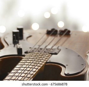 A closeup of the neck of an electric bass with a shallow photographic depth of field and bokeh effect - Shutterstock ID 675686878