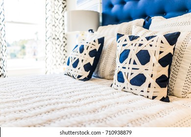 Closeup Of New Bed Comforter With Decorative Pillows In Bedroom In Staging Model Home, House Or Apartment