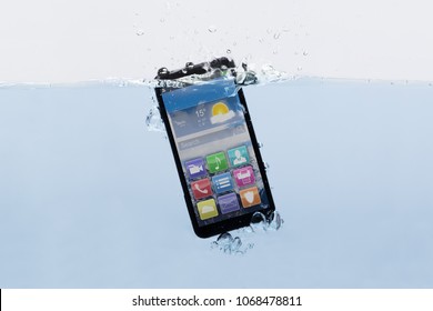 Close-up Of A New Black Mobile Phone Submerged In Water