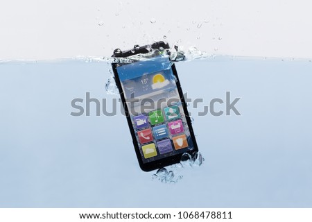 Close-up Of A New Black Mobile Phone Submerged In Water