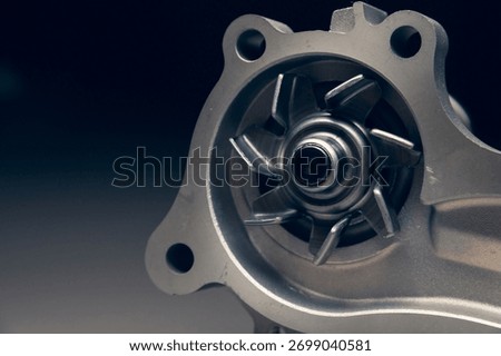Close-up of a new internal combustion engine cooling water pump on a gray background.