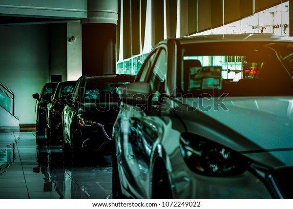 Closeup new luxury compact car parked in\
modern showroom for sale. Car dealership office. Car retail shop.\
Electric car technology and business\
concept