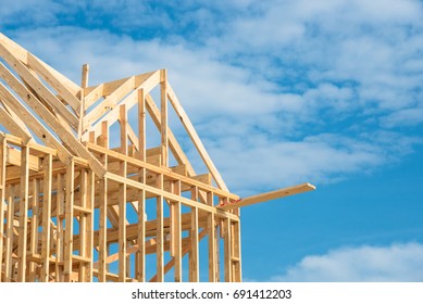 Closeup New Stick Built Home Under Construction Under Blue Sky In Humble, Texas, US. Framing Structure/wood Frame Of Wooden Houses/home. House Construction And Real Estate Concept Background. Panorama