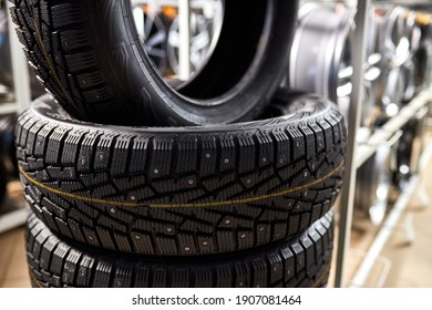 Close-up New Tires In The Auto Repair Service Center, Brand New Winter Tires With A Modern Tread Isolated. Selective Focus. Tire Stack Background.winter Season, No People