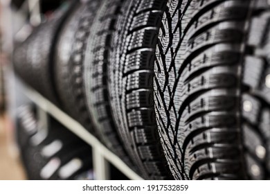 close-up new tires in the auto repair service center, brand new winter tires with a modern tread isolated. selective focus. tire stack background.winter season, no people