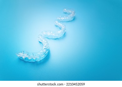 Close-up, New Transparent Braces Lie In A Row On A Blue Background. Suitable For Dental Clinic Banner