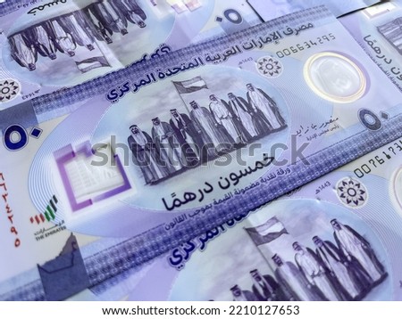 Closeup of new UAE 50 dirhams currency notes, paper money, against white background, released on Dec, 2021 to mark Golden jubilee. Finance and Economy concepts.