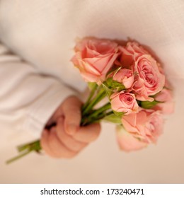 Close-up Of Newborn Baby Hand Holding A Bouquet Of Flowers, Tiny Pink Roses. New Life, Love And Holiday Concept, Ready For Your Logo, Text Or Symbols. Retro Style.