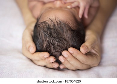 Close-up Newborn Baby On Hand With Lots Of Dark Hair